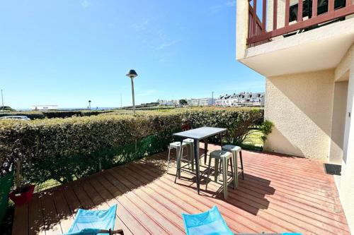 un patio avec une table et des chaises sur un balcon dans l'établissement Joli appartement cosy Terrasse face à la mer, à Ploemeur