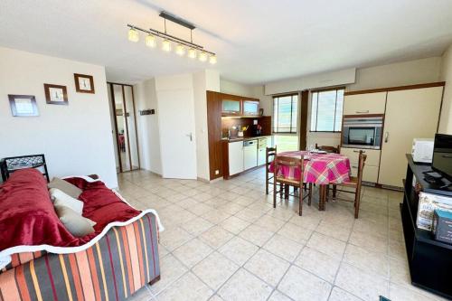 Il comprend un salon avec un lit et une cuisine avec une table. dans l'établissement Joli appartement cosy Terrasse face à la mer, à Ploemeur