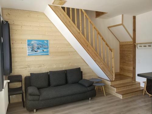 a living room with a couch and a staircase at Les Balcons de L'Izoard in Arvieux