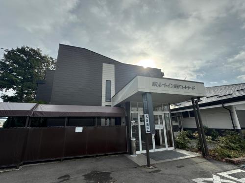 a building with a sign in front of it at Hotel Route-Inn Dai-ichi Nagano in Nagano