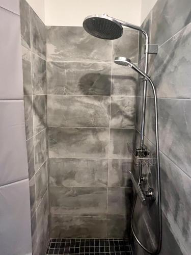 a shower with a glass door in a bathroom at Stylish Stay in Ēveles Street in Rīga