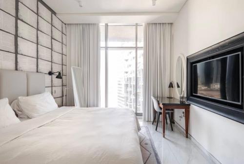 una camera con letto, TV e scrivania di Atria Business Bay a Dubai