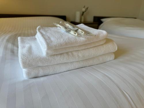 einen Stapel Handtücher auf einem Bett in der Unterkunft Cooee Fuji Yamanakako 大型ジャグジーバス完備 最大8名宿泊可能 一軒家を貸切 in Yamanakako