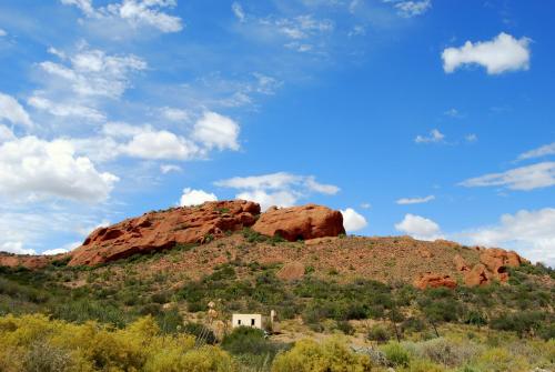 a house on top of a hill with red rocks at Amber Lagoon Backpackers Lodge in Vleirivier