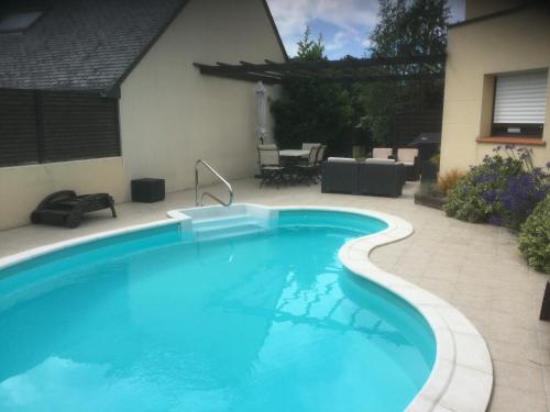 a large blue swimming pool in a yard at Gîte du Clos de Kério in Guidel