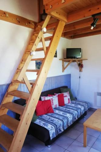 Cette chambre dispose d'un canapé et d'un escalier en bois. dans l'établissement Appartement chaleureux à Gresse-en-Vercors 43 m² vue montagne, à Gresse-en-Vercors