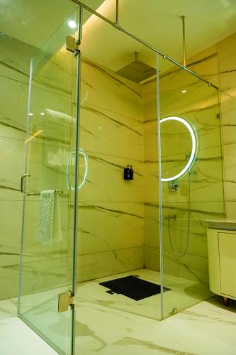GajraulaにあるHotel Adsan Heightsの浴室のガラス扉付きシャワー
