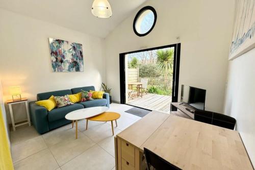 un salon avec un canapé et une table dans l'établissement Maisonnette Hyper Cosy 200m du port de Lomener, à Ploemeur