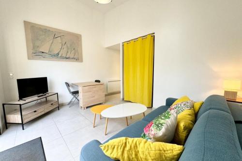 un salon avec un canapé bleu et une télévision dans l'établissement Maisonnette Hyper Cosy 200m du port de Lomener, à Ploemeur