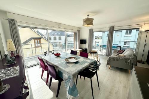 un salon avec une table, des chaises et un canapé dans l'établissement Spacieux T4 neuf de standing Plein bourg, à Larmor-Plage