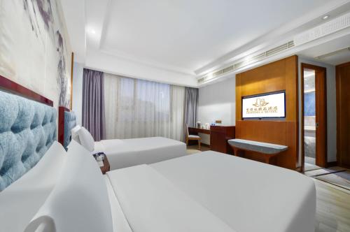 Una habitación de hotel con dos camas y un escritorio. en Hendra Hotel - Wenzhou Longwan International Airport Yongzhong Metro Station Branch, en Wenzhou