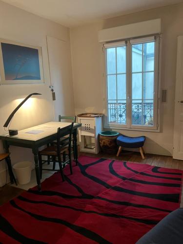 - un salon avec une table et un tapis dans l'établissement Montmartre joli 2 pièces au pied du Sacré Coeur, à Paris