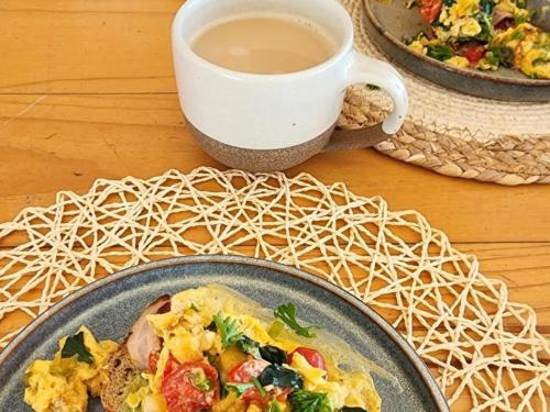 ランゲバーンにあるLangebaan Guest Houseの食べ物の皿とコーヒーカップが置かれたテーブル