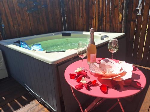 a hot tub with a table with two glasses of wine at Tree Living in Krugersdorp