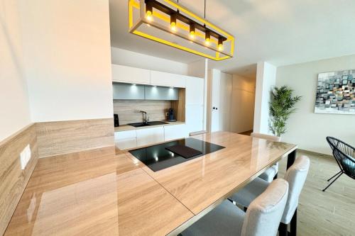 une cuisine avec une grande table et des chaises en bois dans l'établissement T3 de standing Plein bourg - 100m des plages, à Saint-Pierre-Quiberon