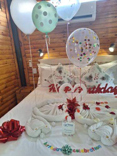 a bed with balloons and some towels and balloons at Tree Living in Krugersdorp