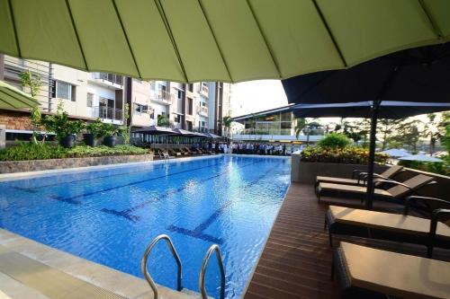 a large swimming pool with chairs and umbrellas at Matina Enclave in Davao City