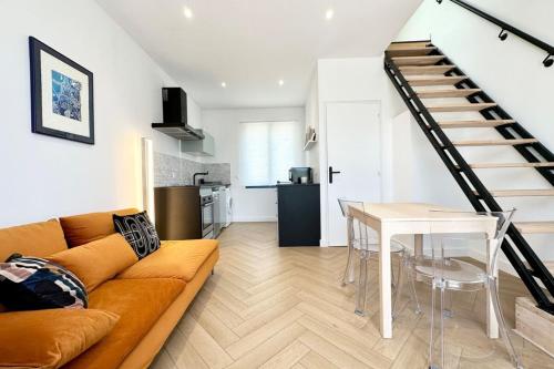 - un salon avec un canapé, une table et un escalier dans l'établissement Lovely ! Duplex de standing neuf 250m des plages, à Larmor-Plage