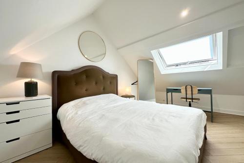 une chambre avec un lit avec une commode et un miroir dans l'établissement Lovely ! Duplex de standing neuf 250m des plages, à Larmor-Plage