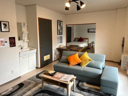 a living room with a couch and a bed at レジデンス平岸 in Minami-jūichijō