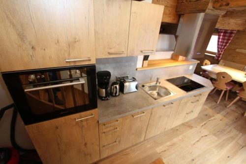 a small kitchen with a sink and a stove at Hennleiten Hütte in Reith bei Kitzbühel
