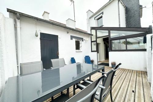 une table et des chaises en verre sur le balcon d'une maison dans l'établissement Maison de pêcheur Rénovée À 50m des plages, à Riantec