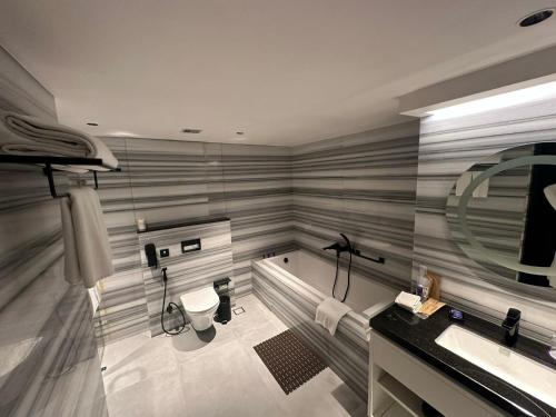 a bathroom with a sink and a toilet and a mirror at Vivanta Meghalaya Shillong in Shillong
