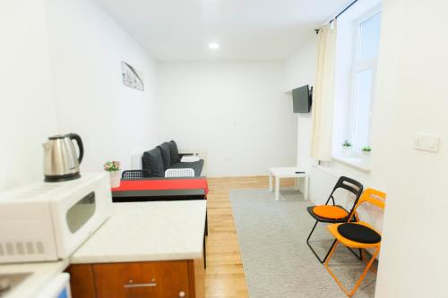uma cozinha e sala de estar com micro-ondas e cadeiras em Fifty Apartments em Zagreb