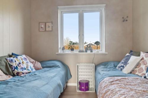 two beds in a room with a window at House With A Beautiful View Of The Sea And Bogø in Stubbekøbing