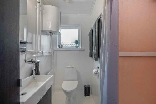 a white bathroom with a toilet and a sink at Holiday Home In Beautiful Martofte in Martofte