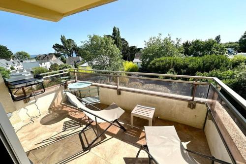 d'un balcon avec des chaises et une table sur le toit. dans l'établissement T2 refait à neuf À 2 pas du bourg et des plages, à Larmor-Plage