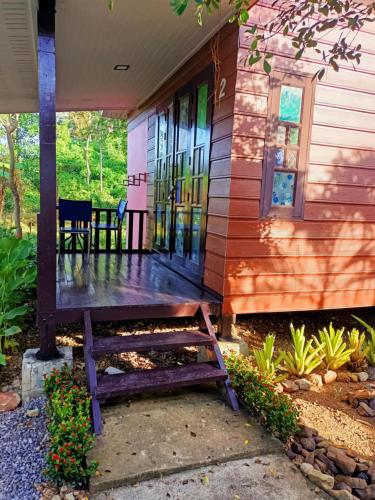 a wooden bench sitting on the front porch of a house at DD Beach Houses in Phra Ae beach
