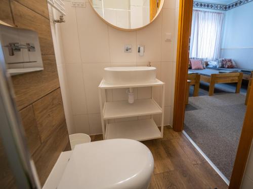 a bathroom with a white toilet and a sink at Zajazd w Biskupinie in Biskupin