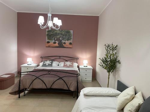 a bedroom with a bed and a chandelier at B&B Tregì in Lamezia Terme