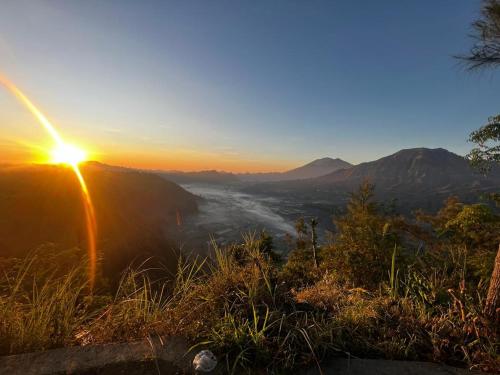 a view of the sun setting over a valley at Ayodya Batur Villa in Kintamani