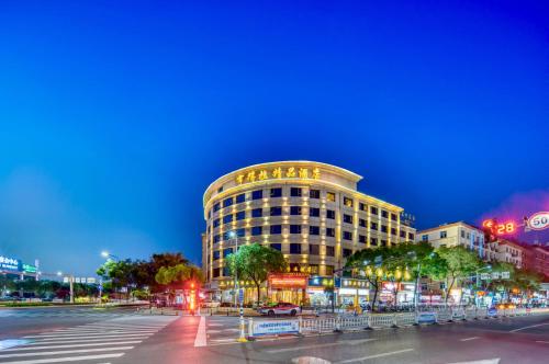un edificio con un cartel en una calle de la ciudad en Hendra Hotel - Wenzhou Longwan International Airport Yongzhong Metro Station Branch, en Wenzhou