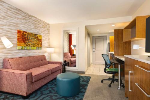 a living room with a couch and a desk at Home2 Suites by Hilton Denver West / Federal Center in Lakewood