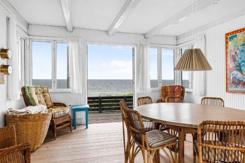 a dining room with a table and chairs and the ocean at Welcoming Holiday Home Right Down To The Water in Rørvig