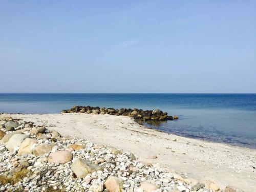 a group of rocks on a beach in the water at Welcoming Holiday Home Right Down To The Water in Rørvig