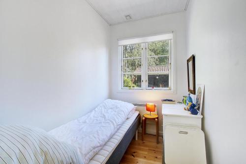 een slaapkamer met een bed en een bureau met een raam bij Unique, Artistic House With Fjord View in Holbæk