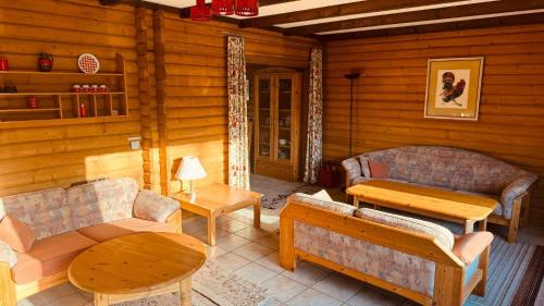 a living room with couches and tables in a log cabin at Ferienwohnung Sonnenblick in Arrach in Arrach