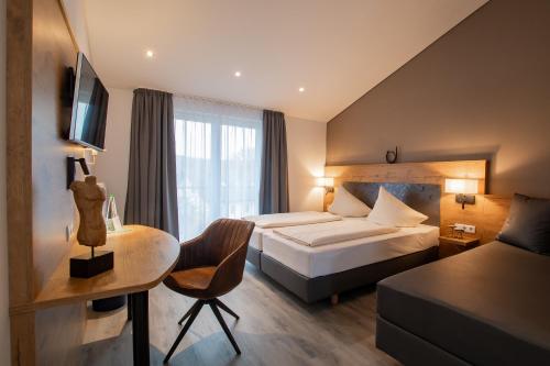 a hotel room with a bed and a desk at Hotel & Restaurant Bestenheider Stuben in Wertheim