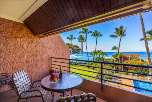 a balcony with a table and chairs and a view of the ocean at Kuleana Club #320 - Ocean View -1 bedroom & 1 bathroom - 3rd Floor in Kahana