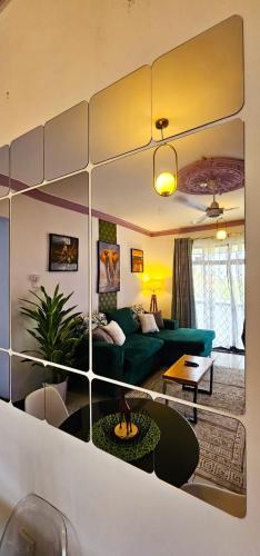 a living room with a green couch and a mirror at Kian Nest in Mombasa