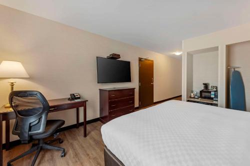 a hotel room with a bed and a desk with a computer at Quality Inn in Ottawa