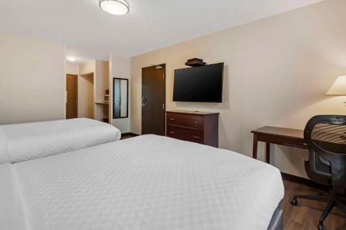 a hotel room with two beds and a desk and a television at Quality Inn in Ottawa
