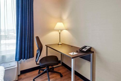 a desk with a lamp and a chair in a room at Quality Inn in Ottawa