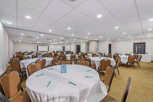 a room filled with tables and chairs with white table cloth at Quality Inn in Ottawa