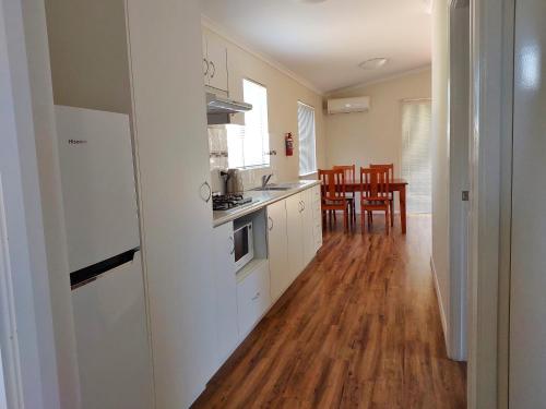 a kitchen with white cabinets and a wooden floor at Mt Barker Holiday Park - Western Australia in Mount Barker