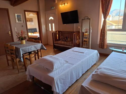 a bedroom with two beds and a table and a crib at Belleza Villa in Lixouri